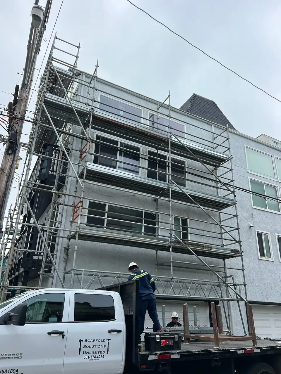 Scaffold on the front of a three-story stucco apartment building