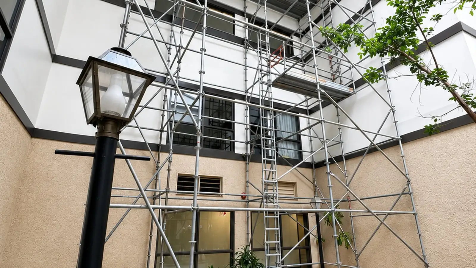 Scaffold set against the exterior of a medical office building beside a lamp post